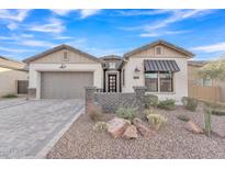 Single-story home with gray garage door and brick accents at 8043 E Jaeger St, Mesa, AZ 85207