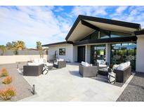 Outdoor seating area with grey tile flooring and a modern home in the background at 12201 N 65Th St, Scottsdale, AZ 85254