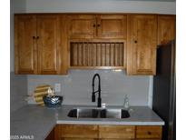 Modern kitchen sink with updated faucet and cabinetry at 5031 W Flynn Ln, Glendale, AZ 85301