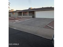 Ranch style home with a large driveway and well-manicured landscaping at 6449 E Dodge St, Mesa, AZ 85205