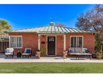 Charming brick home with a cozy front porch seating area and green lawn at 6811 N 11Th Ave, Phoenix, AZ 85013