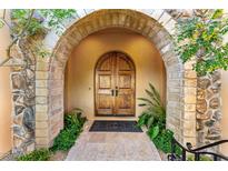 Elegant double wooden doors with stone arch entryway at 9630 E Mountain Spring Rd, Scottsdale, AZ 85255