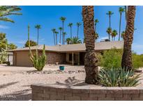 Single-story home with desert landscaping and a two-car garage at 12059 S Paiute St, Phoenix, AZ 85044