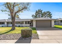 Single-level home with a two-car garage and well-manicured lawn at 12539 W Shadow Hills Dr, Sun City West, AZ 85375