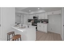 Modern white kitchen with island, new appliances, and dark green tile backsplash at 13614 N Hawthorn Dr, Sun City, AZ 85351