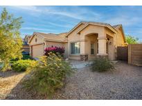 Single-story home with landscaped front yard, attached two-car garage, and neutral color scheme at 16549 W Desert Ln, Surprise, AZ 85388