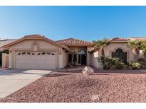 Single-story home with a two-car garage and desert landscaping at 19662 N 93Rd Dr, Peoria, AZ 85382