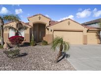 Tan house with 3-car garage, landscaping, and desert plants at 23618 W Adams St, Buckeye, AZ 85396