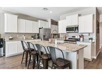 Modern kitchen with granite countertops, stainless steel appliances, and an island at 29681 W Columbus Ave, Buckeye, AZ 85396