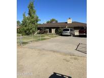 Ranch style home with large driveway and mature trees at 4038 W Morrow Dr, Glendale, AZ 85308