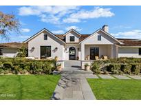 Stunning white farmhouse exterior with a welcoming front porch and lush landscaping at 5314 E Calle Del Norte --, Phoenix, AZ 85018