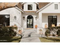 Inviting front entrance features a black arched doorway, stylish lanterns, and manicured landscaping at 5314 E Calle Del Norte --, Phoenix, AZ 85018