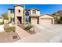 Two-story house with a large front yard, three-car garage, and a paved driveway at 5902 W Gambit Trl, Phoenix, AZ 85083