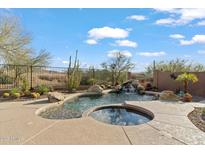 Inviting pool and spa with waterfall feature in a desert landscape setting at 41711 N Maidstone Ct, Anthem, AZ 85086