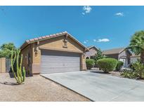 House exterior featuring a two-car garage and desert landscaping at 46166 W Sheridan Rd, Maricopa, AZ 85139