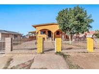 Cute yellow house with arched entryway and a metal fence at 4626 S 8Th St, Phoenix, AZ 85040