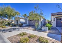 Single story home with neutral exterior, two-car garage, and landscaped front yard at 5015 S Quantum Way, Mesa, AZ 85212