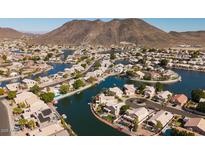 Aerial view of lakefront community with numerous houses and mountain backdrop at 5415 W Pontiac Dr, Glendale, AZ 85308