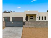 Modern stucco home with two-car garage and gated entry at 744 E Desert Ln, Phoenix, AZ 85042