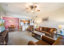 Open-concept living room featuring a ceiling fan, brown sofa, and combined dining and kitchen area at 10136 E Southern Ave # 1045, Mesa, AZ 85209