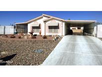 Single-wide manufactured home with carport and landscaped front yard at 106 S 72Nd Way, Mesa, AZ 85208