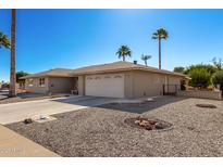 Single story home with a two-car garage and rock landscaping at 11009 W Crestbrook Dr, Sun City, AZ 85351