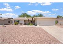Charming single-story home featuring a two-car garage, mature palm trees, and low maintenance desert landscaping at 11802 S Half Moon Dr, Phoenix, AZ 85044