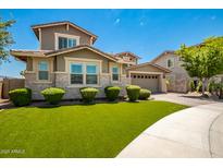 Two-story house with stone accents and a landscaped lawn at 13713 W Harvest Ave, Litchfield Park, AZ 85340