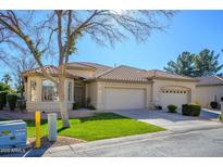 Single-story home with two-car garage and landscaped lawn at 23901 S Vacation Way, Sun Lakes, AZ 85248