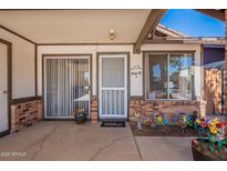 Front entry with screen door and colorful flower pots at 3344 E Crescent Ave, Mesa, AZ 85204