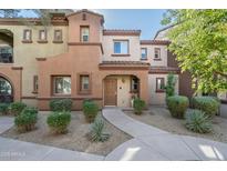 Two-story stucco home with Spanish-style architecture, landscaping, and a walkway at 3935 E Rough Rider Rd # 1235, Phoenix, AZ 85050