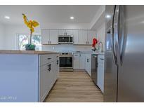 Modern kitchen featuring white cabinets, stainless steel appliances, and a large island at 5725 W Osborn Rd, Phoenix, AZ 85031