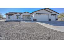 New construction home with a two-car garage and gravel landscaping at 20823 W Rainbow Trl, Buckeye, AZ 85326