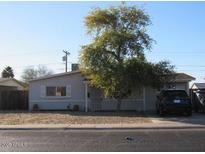 Ranch-style house with a carport and mature tree in front at 14846 N 29Th Ave, Phoenix, AZ 85053
