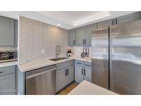 Close-up of a modern kitchen featuring stainless steel appliances, light countertops, and gray shaker cabinets at 2323 N Central Ave # 502, Phoenix, AZ 85004
