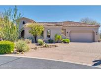 Single-story home with desert landscaping and a three-car garage at 37181 N 103Rd St, Scottsdale, AZ 85262