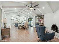Open concept living area with vaulted ceilings, wood floors, and a cozy seating area at 4942 E Wethersfield Rd, Scottsdale, AZ 85254