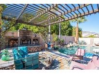 Relaxing pool area with a pergola and fireplace at 758 S Lagoon Dr, Gilbert, AZ 85233