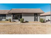 Front view of a charming single story home with tile roof and landscaping at 9027 W Elm St # 5, Phoenix, AZ 85037