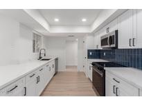 Modern white kitchen with quartz countertops and stainless steel appliances at 10127 W Forrester Dr, Sun City, AZ 85351