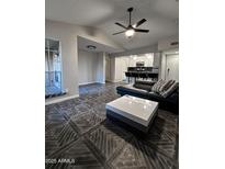 Bright living room with wood-look tile flooring, modern ceiling fan, and updated kitchen view at 200 E Southern Ave # 242, Tempe, AZ 85282
