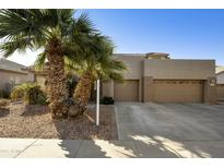 Charming home featuring desert landscaping, palm trees, and a spacious three-car driveway at 4615 W Corral Rd, Laveen, AZ 85339