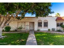 Front view of a light beige stucco house with a walkway and lawn at 5984 N 83Rd St, Scottsdale, AZ 85250