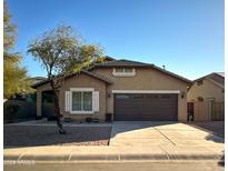 Tan house with brown garage door and landscaping at 1933 S Peppertree Dr, Gilbert, AZ 85295