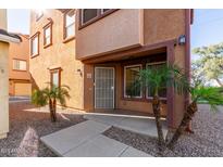 Front view of a two-story townhome with a gated entry and landscaping at 1940 N 78Th Gln, Phoenix, AZ 85035