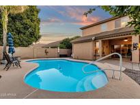 Inviting kidney-shaped pool with patio furniture, ready for summer fun at 3436 E Vaughn Ave, Gilbert, AZ 85234