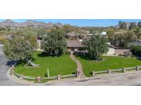 Aerial view of a charming home with a well-manicured front lawn and mature trees at 4022 E Stanford Dr, Phoenix, AZ 85018