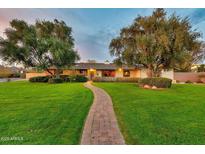 Charming home featuring a brick pathway leading through a lush green lawn to the inviting entrance at 4022 E Stanford Dr, Phoenix, AZ 85018