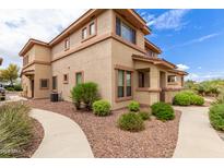 Inviting two-story home with desert landscaping, pathway, and neutral-toned stucco exterior at 42424 N Gavilan Peak Pkwy # 23102, Anthem, AZ 85086