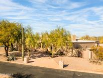 Desert landscape surrounds this single-story home with a tile roof and large windows at 4706 E Rancho Caliente Dr, Cave Creek, AZ 85331